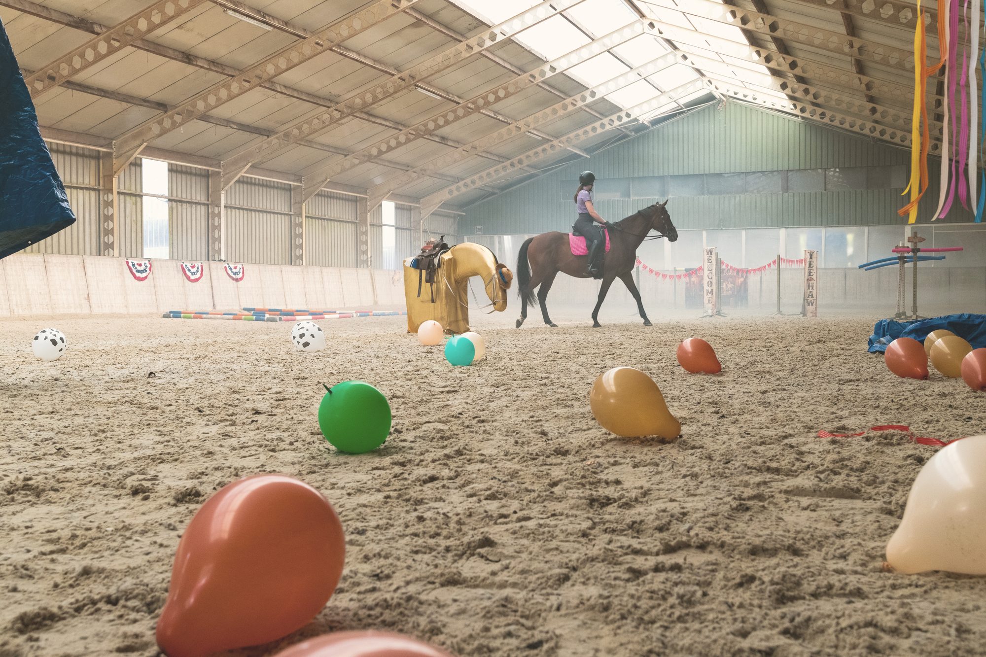 Overzicht van een opgebouwd clinic-parcours met ballonnen, linten en obstakels in de binnenbaan
