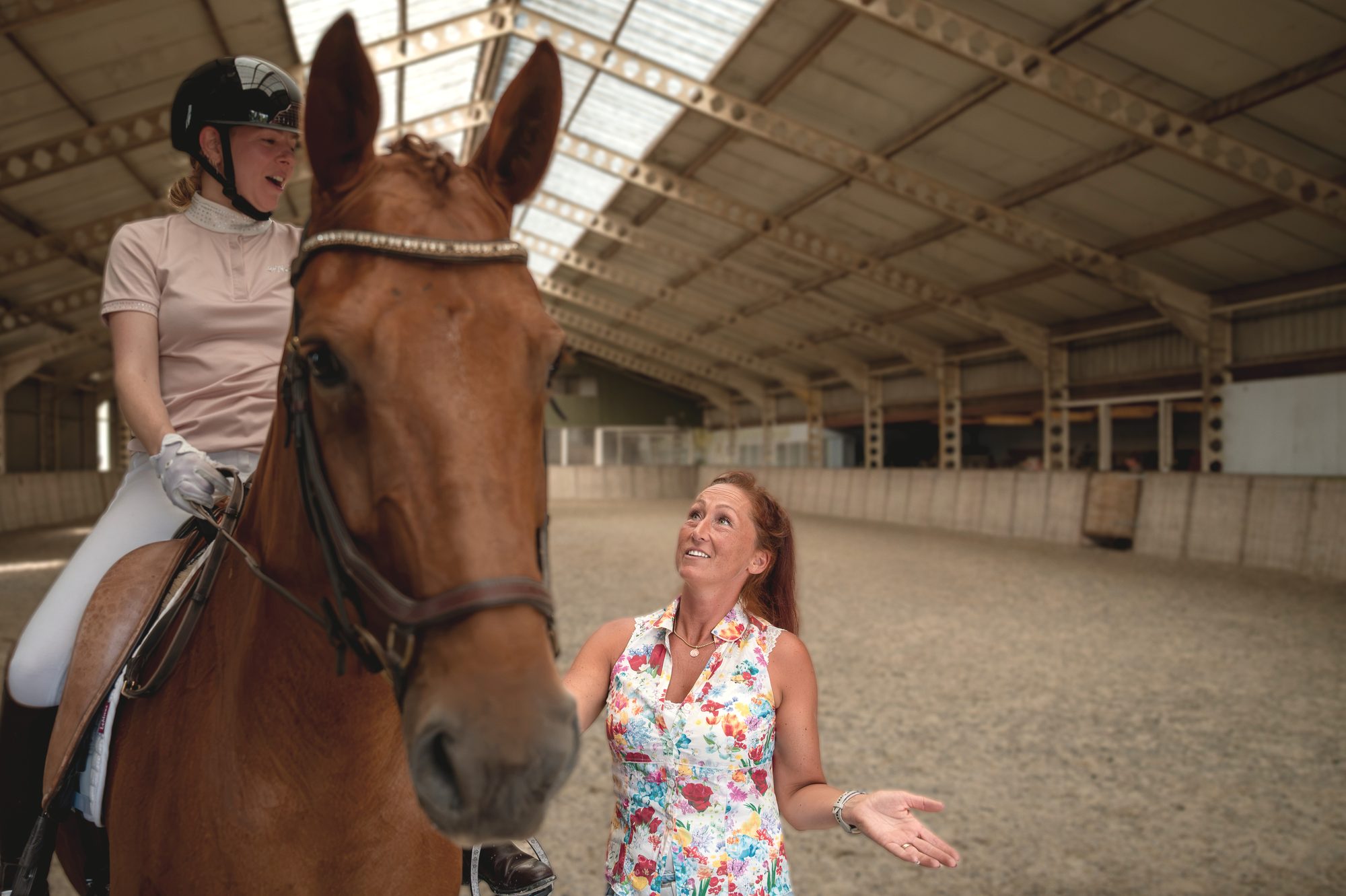 Nicky legt iets uit aan een ruiter te paard in de binnenbaan