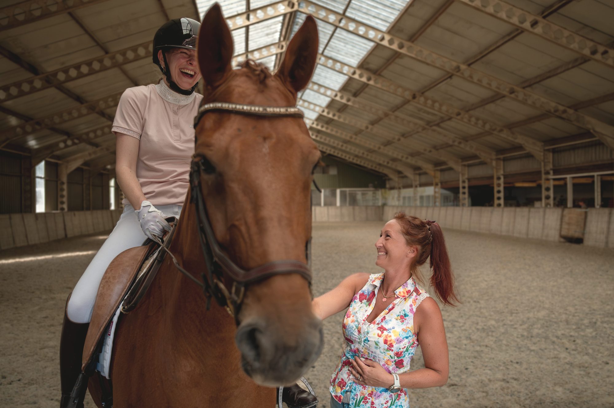 Nicky in gesprek met een lachende ruiter te paard tijdens een clinic