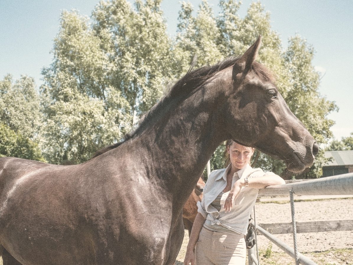 Nicky bij het hek naast Tzigane, haar eerste eigen paard